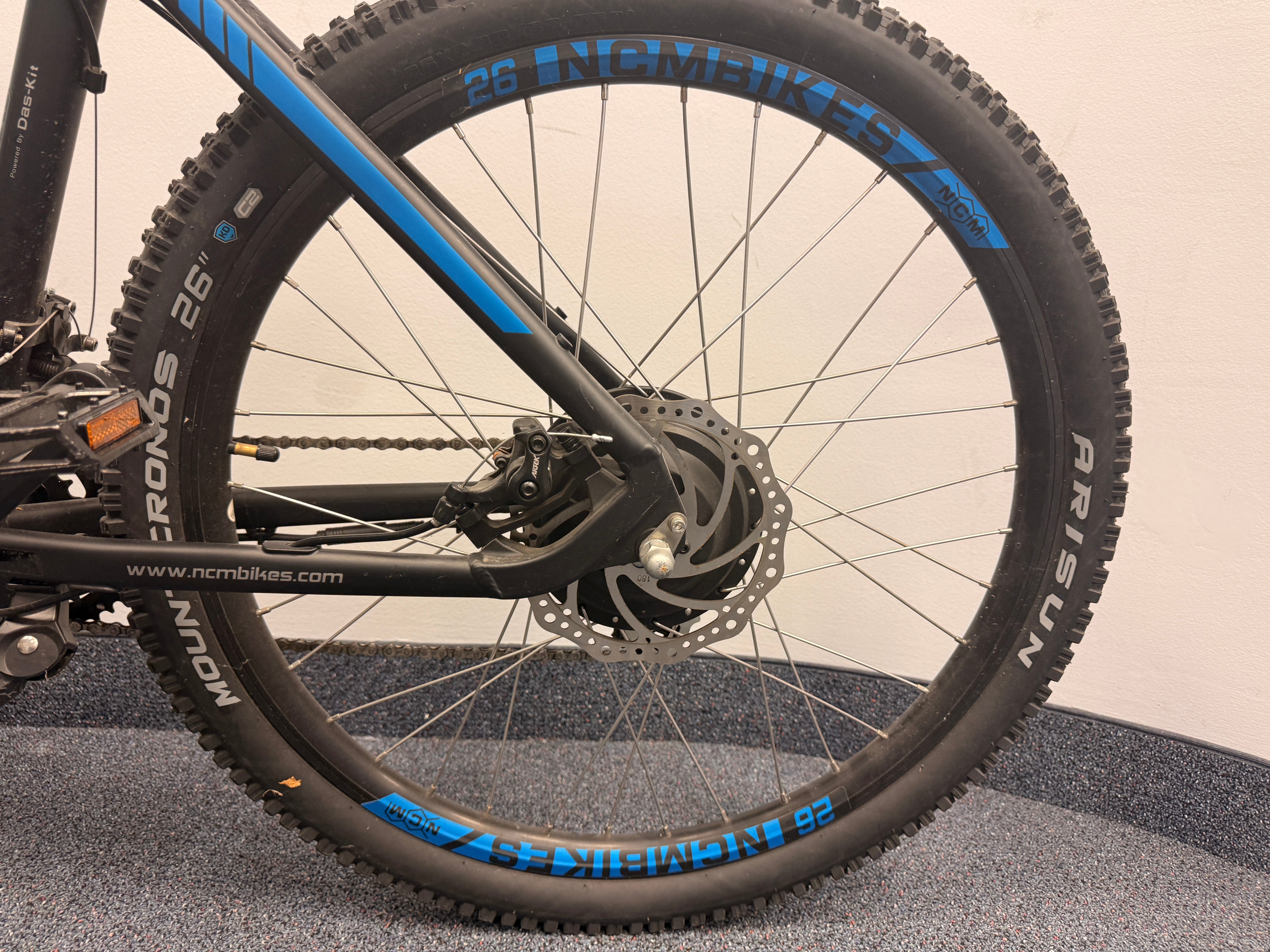 Close-up of a bicycle wheel with visible brand names on a neutral background