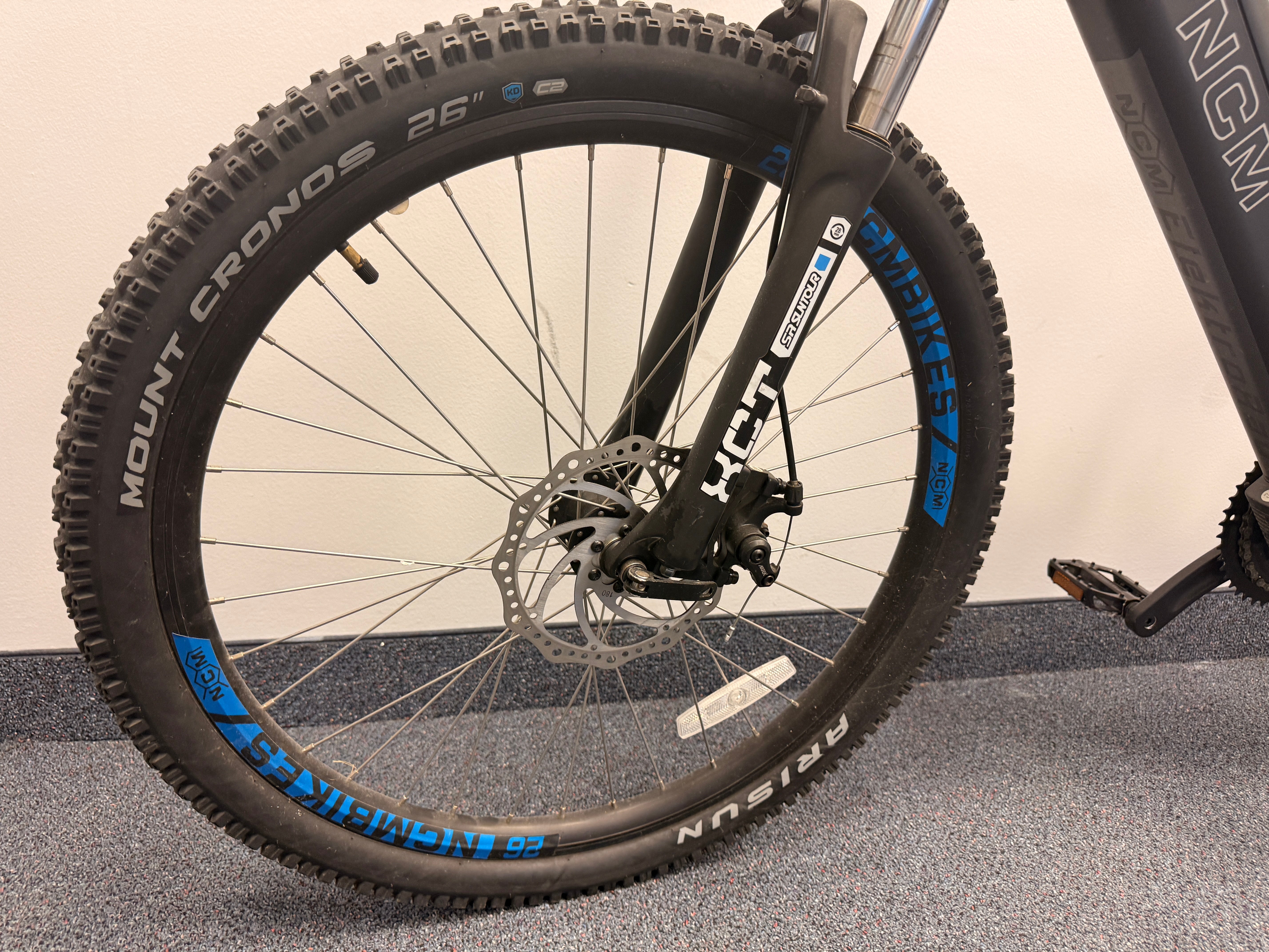 Close-up of a bicycle wheel with visible brand names on a neutral background
