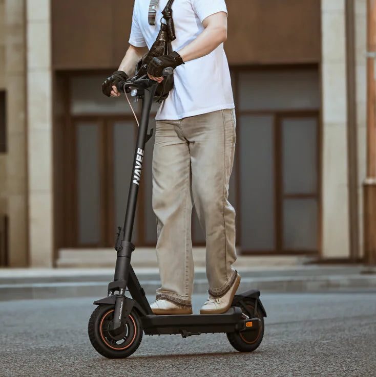 Person riding an electric scooter on a city street.