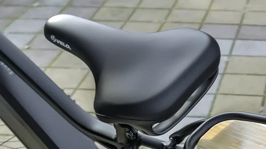 Close-up of a black bicycle seat with 'VELO' branding on a blurred background